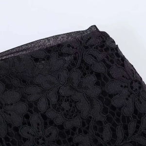 Detailed macro view of black floral lace fabric with delicate mesh and eyelash trim