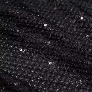Makroaufnahme von schwarzen Pailletten auf Netzgewebe für ein elegantes Abendkleid