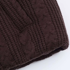 Macro shot of dark brown cable knit pattern and ribbed texture detail on winter jacket