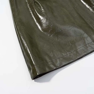 Detail of dark olive glossy faux leather fabric with precise double stitching and textures