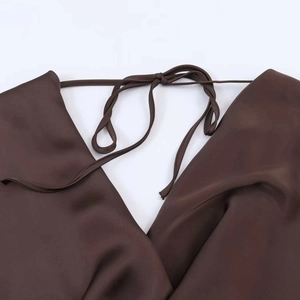 Vue détaillée d'une robe en satin marron foncé avec col en V drapé et bretelles à nouer