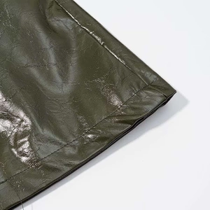 Detail of olive green faux leather hem with precise stitching and glossy wax finish