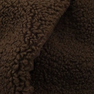 Close-up of premium dark brown teddy fleece fabric texture on winter coat