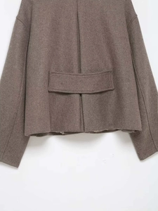 Detail view of the dark brown wool coat back featuring a decorative strap and central pleat