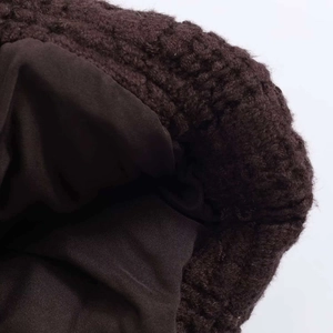 Close-up of deep brown cable knit texture with plush faux fur lining and neat stitching