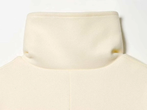 Close-up of cream white wool coat collar with fine stitching and high-end texture