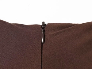 Detail of the hidden zipper and deep coffee brown satin fabric on a slim-fit dress