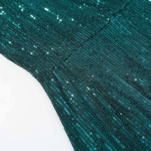 Detail of emerald green sequin fabric with luxury texture on elegant evening dress