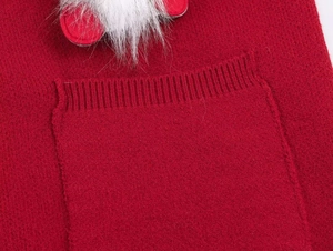 Detail of red knit sweater with festive gnome pocket and white faux fur texture