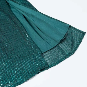 Macro shot of dark green sequins on elegant dress with smooth inner fabric lining