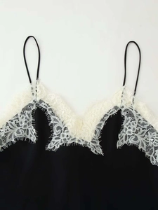 Detailed close-up of V-neck camisole top with elegant white eyelash lace trim and black fabric
