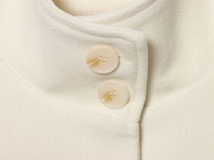 Detailed macro view of wool blend fabric with marble texture buttons on the coat collar