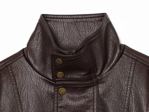 Detail of dark brown leather jacket featuring a stand collar and bronze metal snap buttons