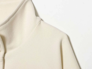 Close-up of cream fleece texture on collar and shoulder of women's autumn coat