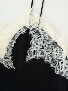 Close-up of black camisole top with delicate white eyelash lace patchwork detailing