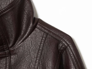 Close-up of the dark brown leather jacket showing natural texture and double stitching