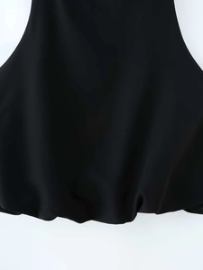 Detail shot of black woven bubble hem on a summer top with subtle sheen and pleated texture