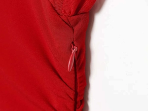 Detail of red mesh dress showing seamless hidden zipper and precise stitching quality