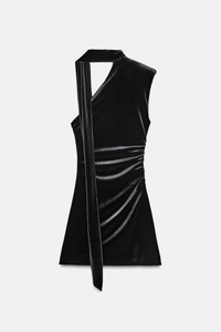 Detail eines schwarzen Samtkleides mit One-Shoulder-Design und stilvollem Halsband-Dekor