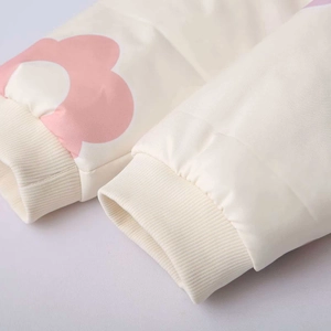 Dettaglio giacca floreale panna con polsini a costine e stampe di petali rosa
