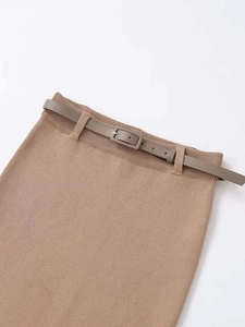Détail d'une jupe en maille marron avec ceinture fine assortie et boucle rectangulaire