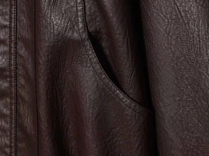Detailed macro view showing the premium dark brown leather texture and pocket stitching
