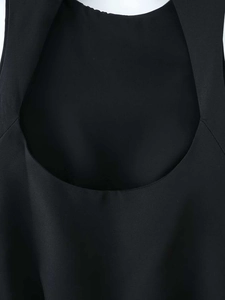 Detailed view of back cut-out design on a black fashion top with minimalist tailoring