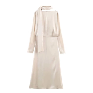 Détail d'une robe en satin champagne élégante avec col à nouer et manches longues