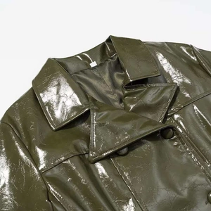 Detailed macro view of olive green patent leather jacket with double-layered collar design