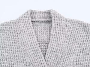 Détail macro du col en maille gaufrée grise montrant la texture épaisse du cardigan long