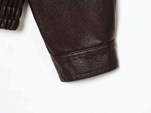 Macro shot of lychee grain leather texture with stitching and elastic cuff detail