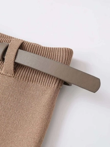 Détail de la jupe en maille côtelée marron avec sa fine ceinture assortie à la taille