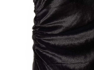Detail aus gerafftem schwarzem Samtstoff mit seidigem Glanz und Faltentextur