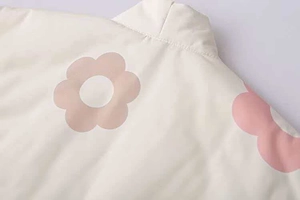 Dettaglio della stampa floreale sulla giacca trapuntata color crema con fiori