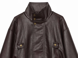 Detail of dark brown leather jacket featuring a stand collar and vintage bronze snaps