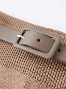 Détail d'une jupe en maille à taille haute avec ceinture en cuir marron et boucle