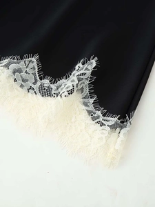 Close-up of black lace-trimmed camisole hem with intricate eyelash floral embroidery