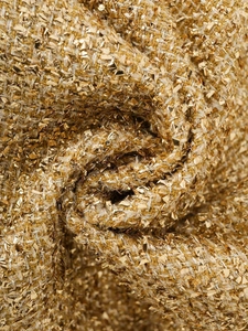 Detailed macro texture of gold metallic sequin tweed fabric for summer jackets