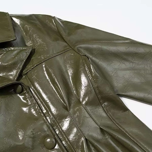 Detail of olive green shiny leather jacket showing smooth texture and matching covered buttons