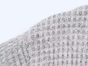 Détail de la texture en maille grise douce sur ce cardigan long et élégant pour femme