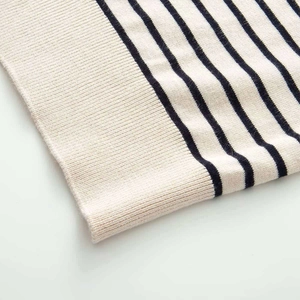 Detail of striped knit cardigan showing ribbed hem and soft cotton blend fabric texture