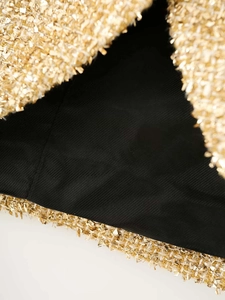 Detail of gold tweed fabric with sequins and contrast black ribbed lining on the jacket