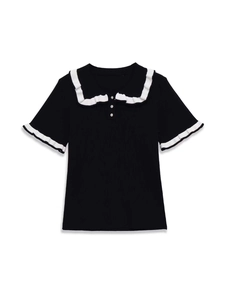 Detail of contrast knit top featuring white ruffled collar and rhinestone buttons