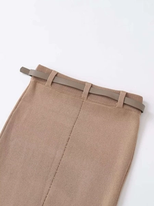 Détail d'une jupe mi-longue en maille à taille haute avec ceinture assortie