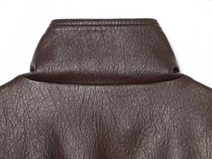 Detail shot of the stand-up collar on a dark brown faux leather jacket with pebble texture