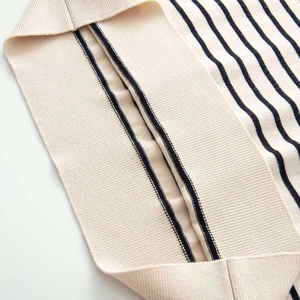 Close-up of beige knit cardigan with fine black stripes and detailed texture fabric