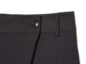 Gros plan détaillé d'un pantalon tissé noir avec fermeture à bouton et passants