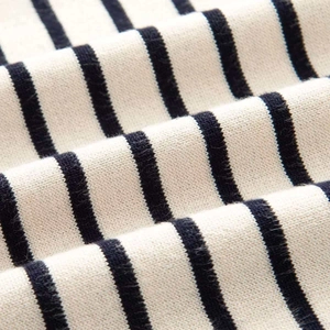 Close-up of soft black and white striped knit texture on a single-breasted jacket