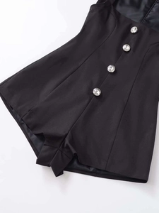 Détail d'un combishort noir avec boutons en strass brillants et doublure en satin