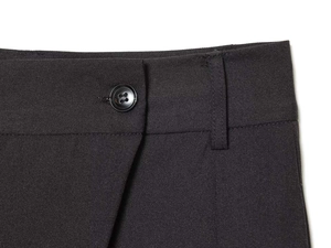 Détail d'un pantalon taille haute avec bouton noir brillant et couture de passant de ceinture